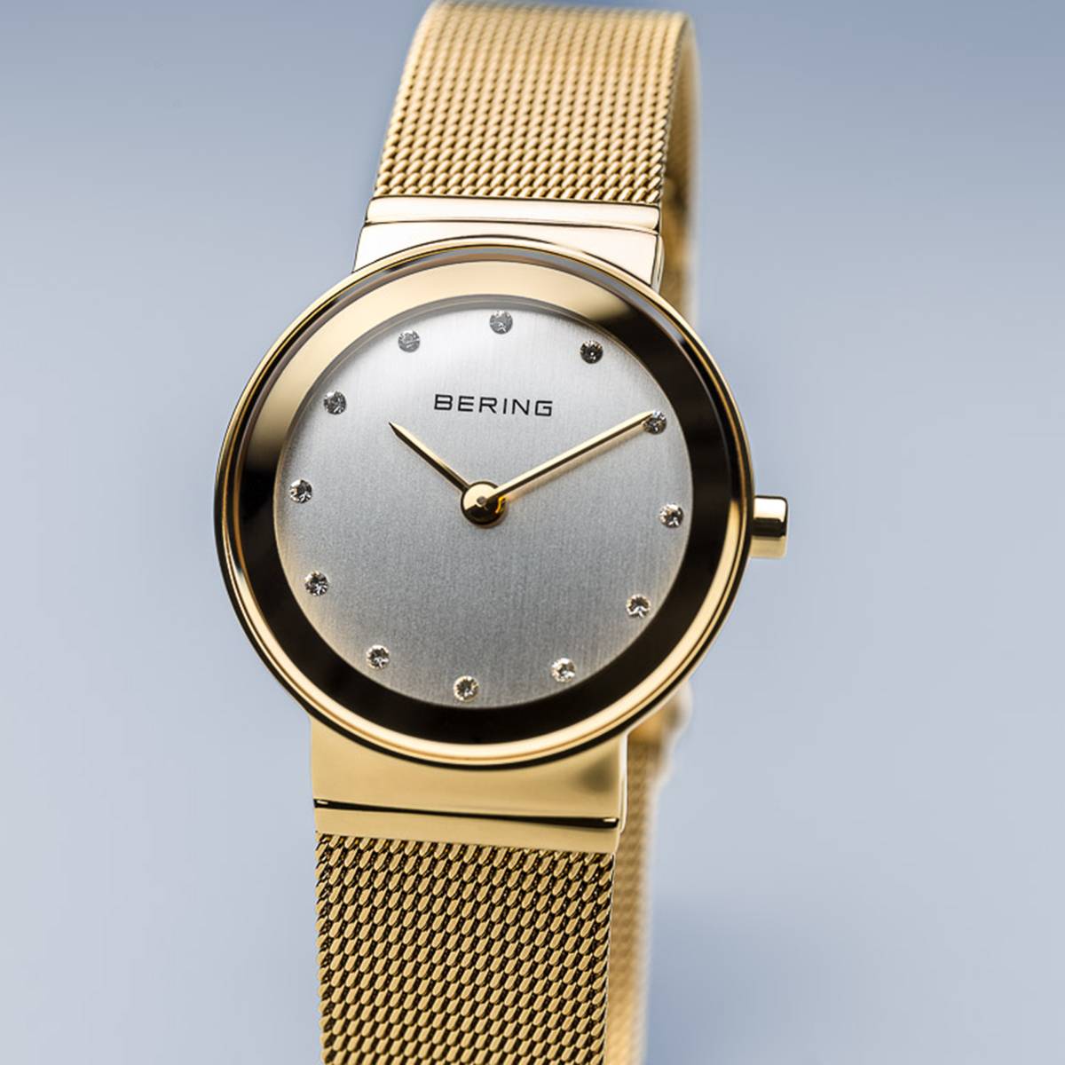 Uhr mit silbernem Zifferblatt, goldfarbenem Gehäuse und goldfarbenem Mesh-Armband