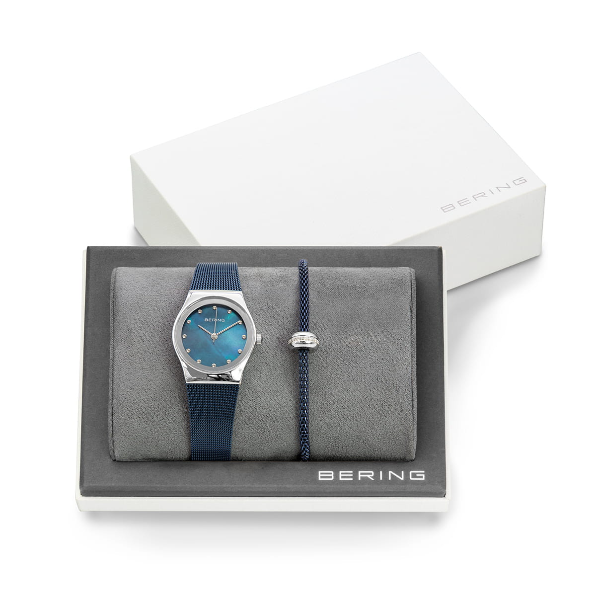 Uhr mit blauem Zifferblatt, silbernem Gehäuse und blauem Silikonarmband, dazu ein schwarzes Armband mit Anhänger