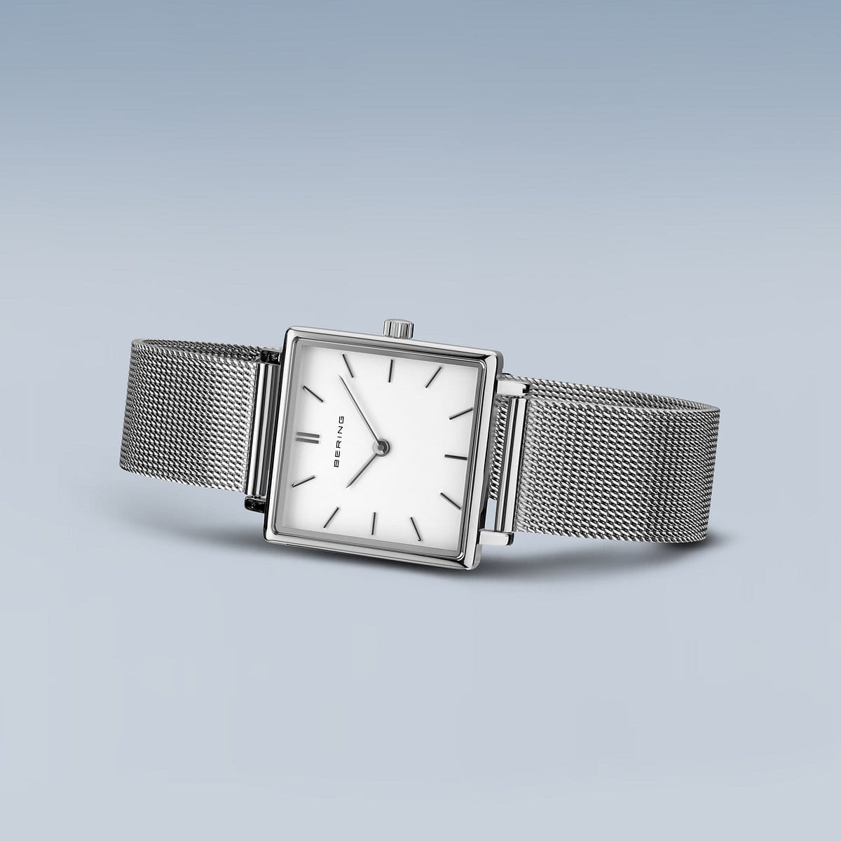 Het Bering dameshorloge 18226-004 toont een minimalistisch vierkant zilveren ontwerp met een quartz uurwerk, duurzaam saffierglas, dunne uurmarkeringen en een subtiele kroon aan de zijkant. Elegant geplaatst op een lichtblauwe achtergrond, heeft het een strakke meshband en een witte wijzerplaat.