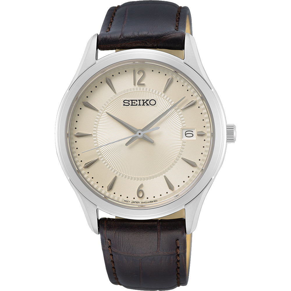 De Seiko herenhorloge SUR421P1 heeft een zilveren kast, beige wijzerplaat en bruine leren band. Het heeft quartz precisie met dunne zilveren wijzers, Arabische cijfers op 12, 3, 6 en 9, een datumvenster op 3 uur - alles onder duurzaam Saffierglas.