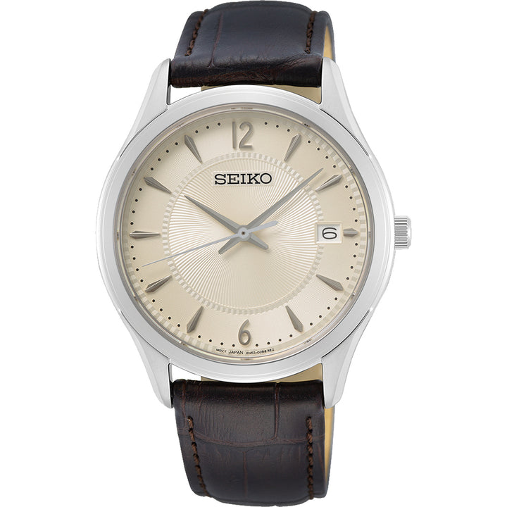 De Seiko herenhorloge SUR421P1 heeft een zilveren kast, beige wijzerplaat en bruine leren band. Het heeft quartz precisie met dunne zilveren wijzers, Arabische cijfers op 12, 3, 6 en 9, een datumvenster op 3 uur - alles onder duurzaam Saffierglas.
