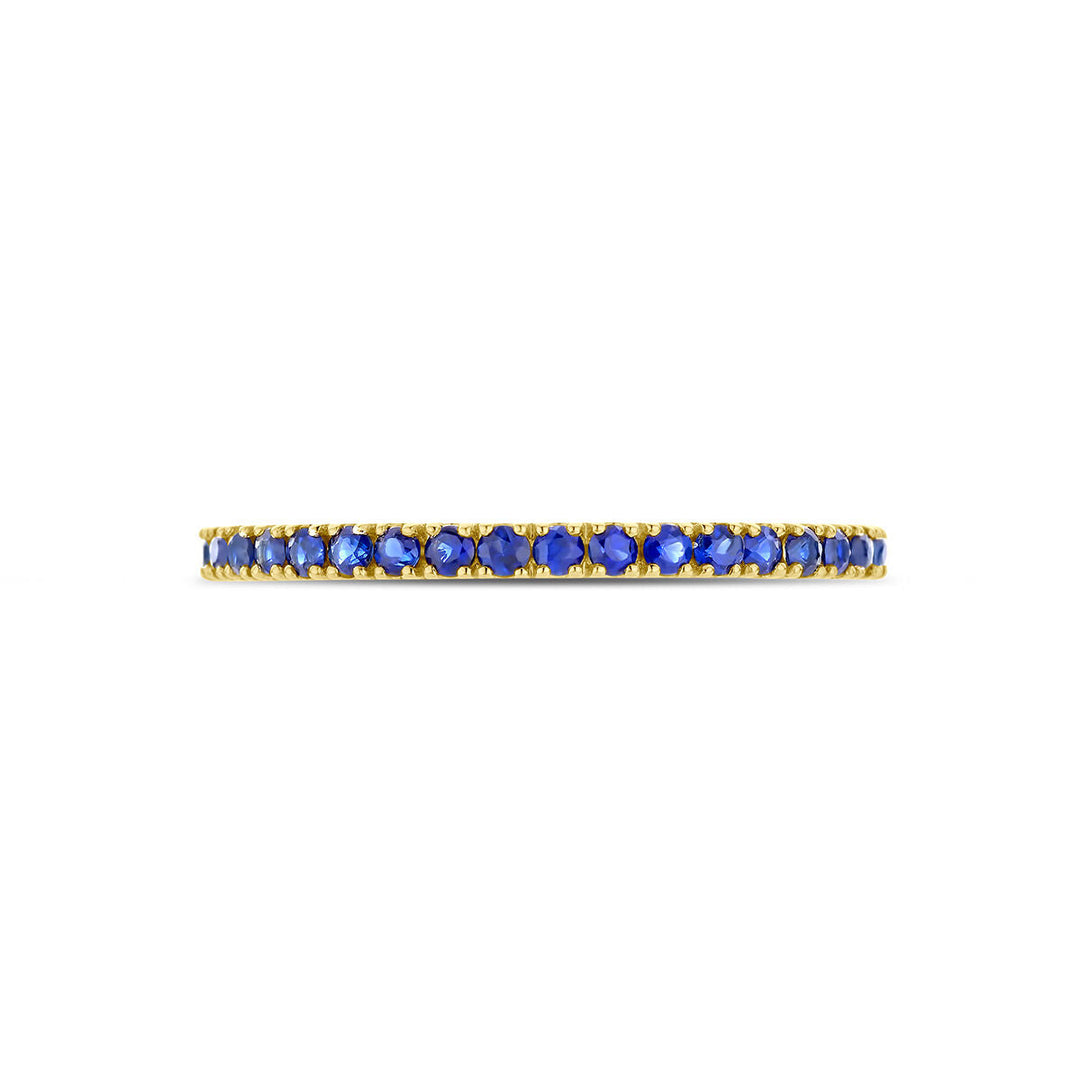 De Van der Kooij Collectie ring met geboortesteen saffier september is een minimalistische 14K geelgouden ring, gezet met kleine ronde blauwe saffieren rondom de band.