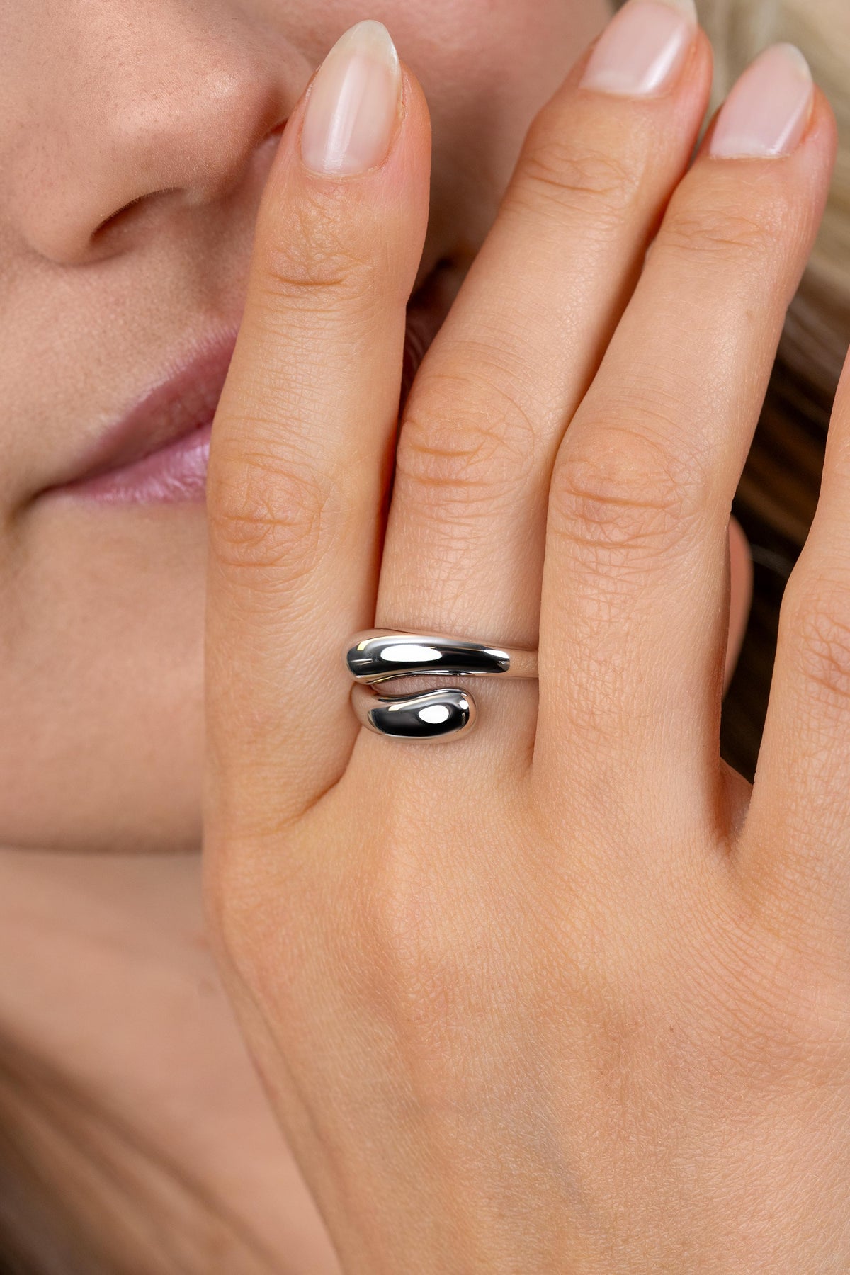 Silberner Ring mit organischer Form, glänzende Oberfläche und zwei geschwungene Elemente