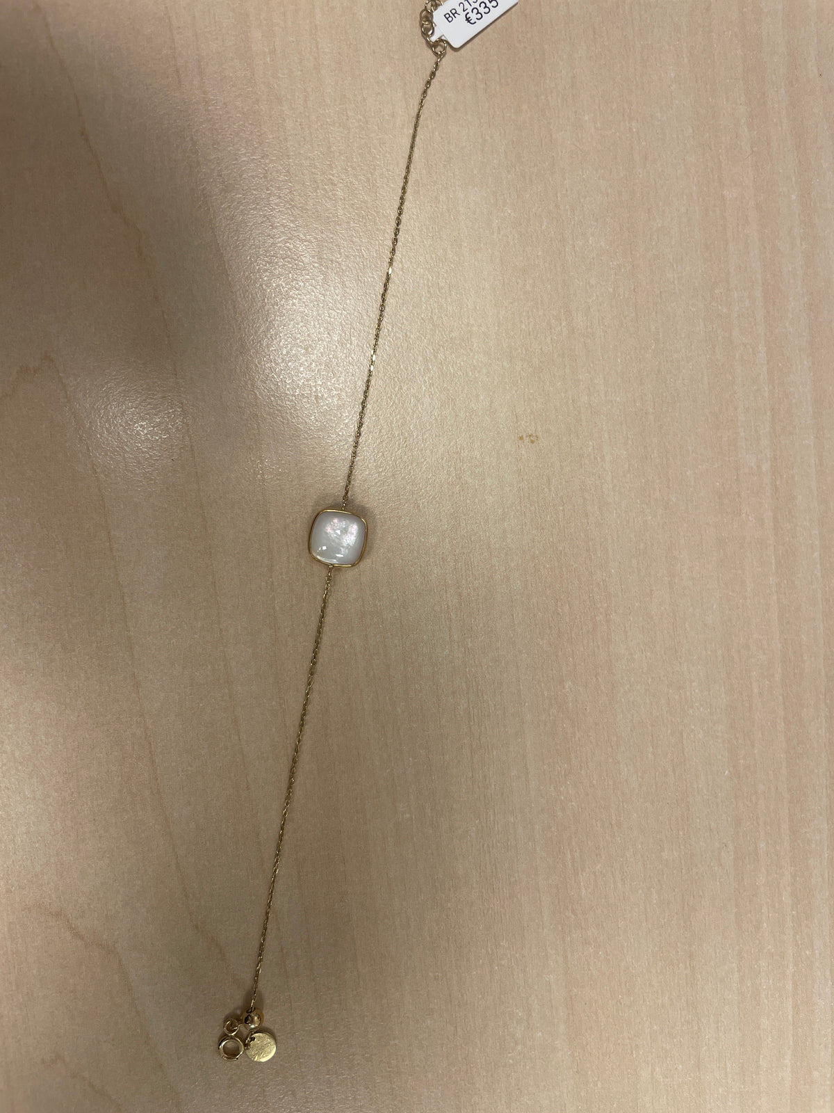 Armband aus Gold mit quadratischem, perlmuttfarbenem Anhänger und kleinen, runden Anhängern
