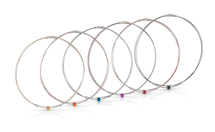 De Collier Klein Kubusje Blauw C230B van CLIC Creations heeft zeven metaalkleurige draadkabels, elk met een gekleurd label in roze, oranje, rood, paars, blauw, groen en zwart. Dit verbluffende stuk integreert een bajonetsluiting voor extra flair.