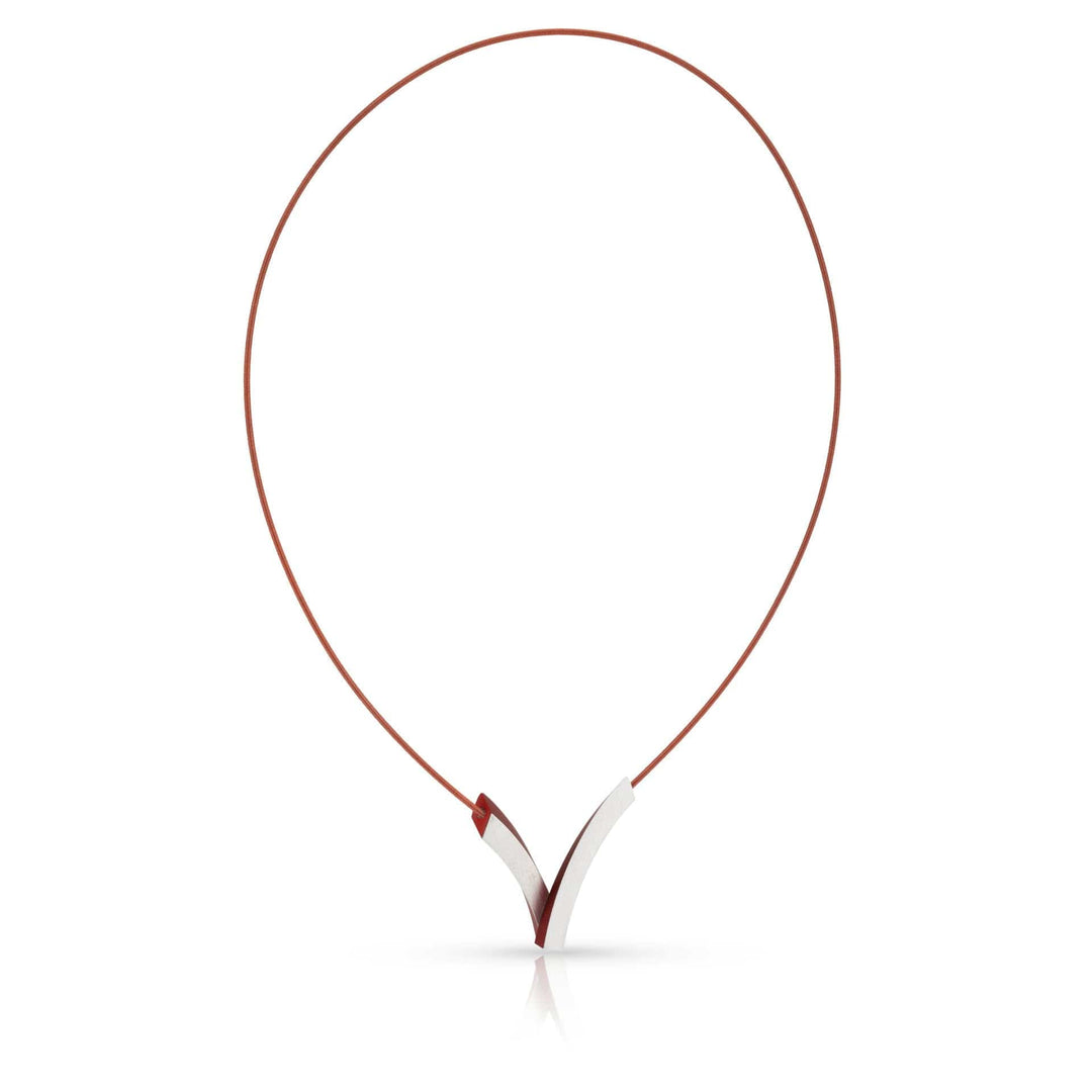 De Collier V-Bogen op elkaar Rood C255R van CLIC Creations heeft een strak, modern design met een dun bruin koord en minimalistische zilveren V hanger, compleet met een magnetische sluiting voor eenvoudig dragen. Deze Dutch Design Sieraad is elegant geplaatst tegen een witte achtergrond.