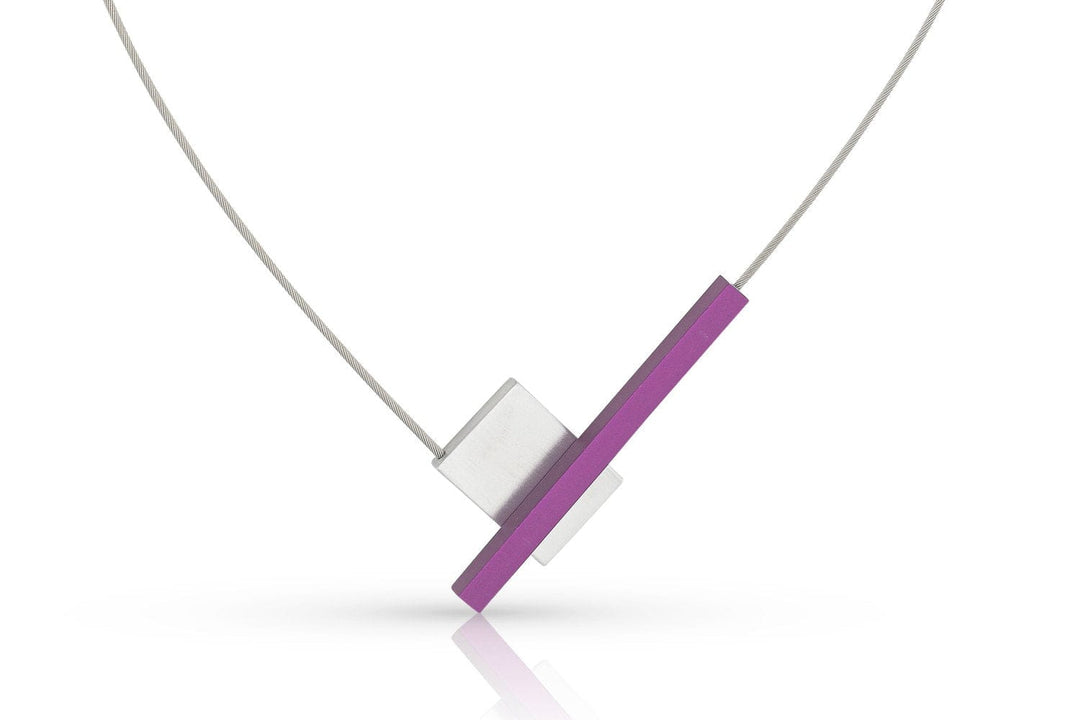Ontdek de charme van CLIC Creations minimalistische Collier V-vorm met staafje C261P, gemaakt in Nederland. Het bestaat uit een zilveren rechthoekig stuk met een diagonale paarse balk, elegant hangend aan een dunne zilveren ketting met een magnetische sluiting.