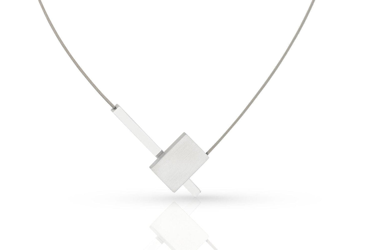 De Collier V-vorm met staafje C261 van CLIC Creations is een minimalistische zilveren ketting met een geometrische hanger, bestaande uit een overlappende rechthoekige vorm en een dun staafje, bevestigd aan een fijne ketting met een magneetsluiting, tegen een witte achtergrond.
