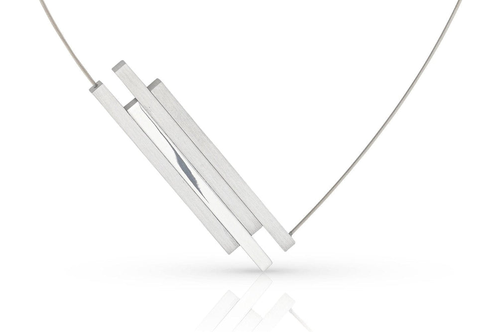 De C264-ketting van Clic Creations heeft een minimalistisch ontwerp met drie dunne, rechthoekige zilveren staafjes die aan een fijne ketting zijn bevestigd. Hierdoor ontstaat een geometrische en eigentijdse look tegen een witte achtergrond.