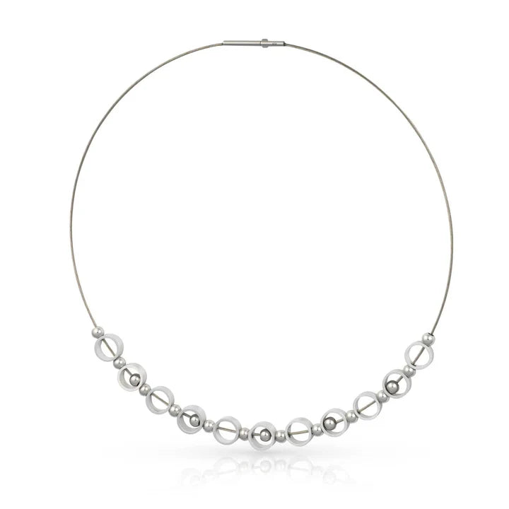 Collier mit silberfarbenen, runden Perlen in verschiedenen Größen auf einem dünnen Draht.