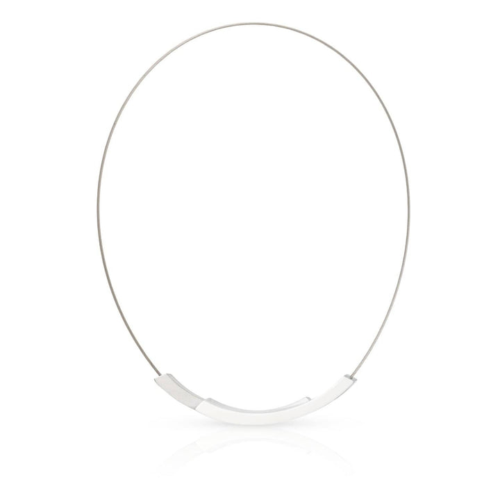 De CLIC Creations Collier Bogen C74 is een minimalistische zilveren ketting met een dunne draad en een gepolijst gebogen metalen middenstuk. Deze halsketting met magneetsluiting wordt weergegeven op een effen witte achtergrond en toont eenvoud en elegantie, en belichaamt de principes van Uniek design.