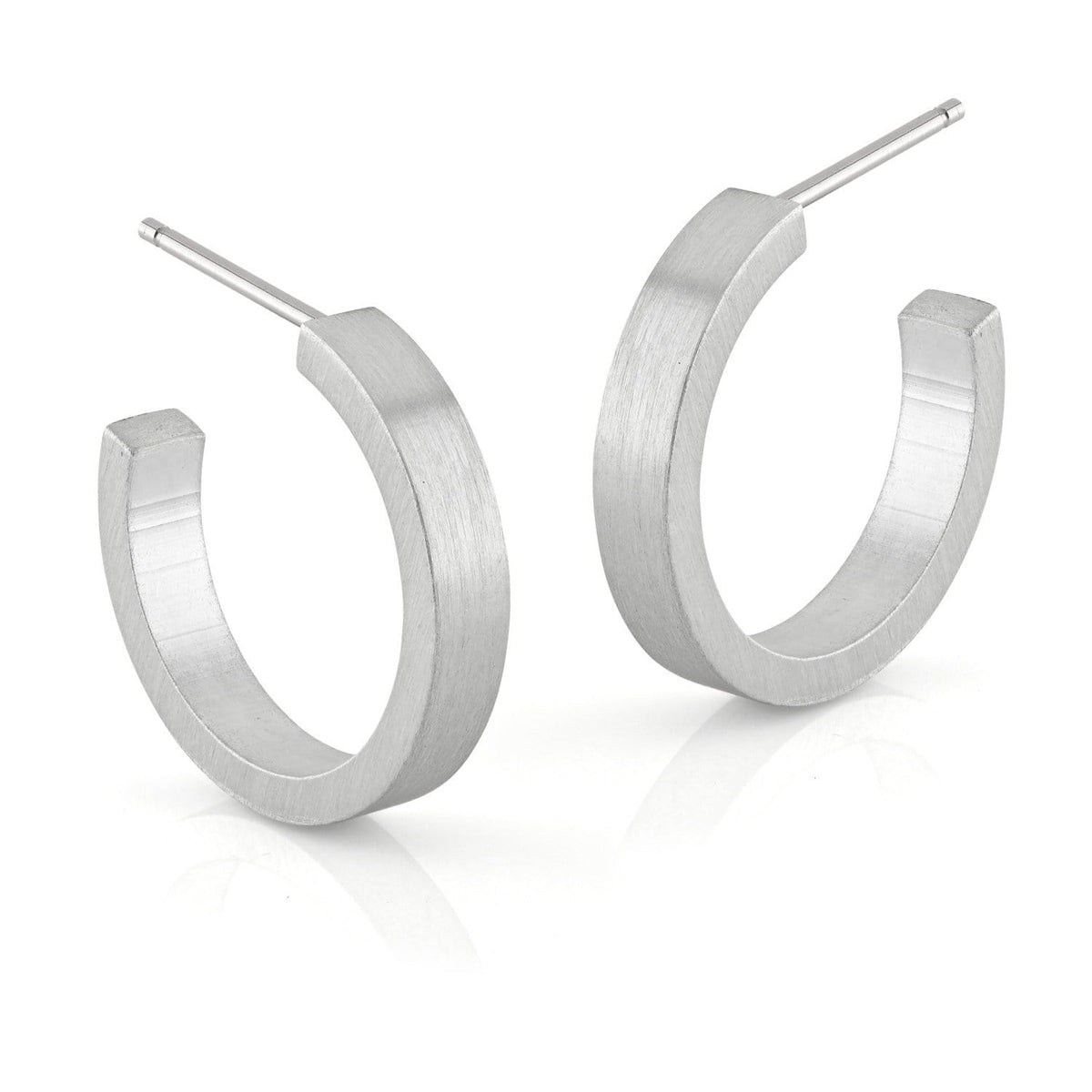 Runde Creolen aus mattem Silber mit flacher, breiter Form und schlichten Details