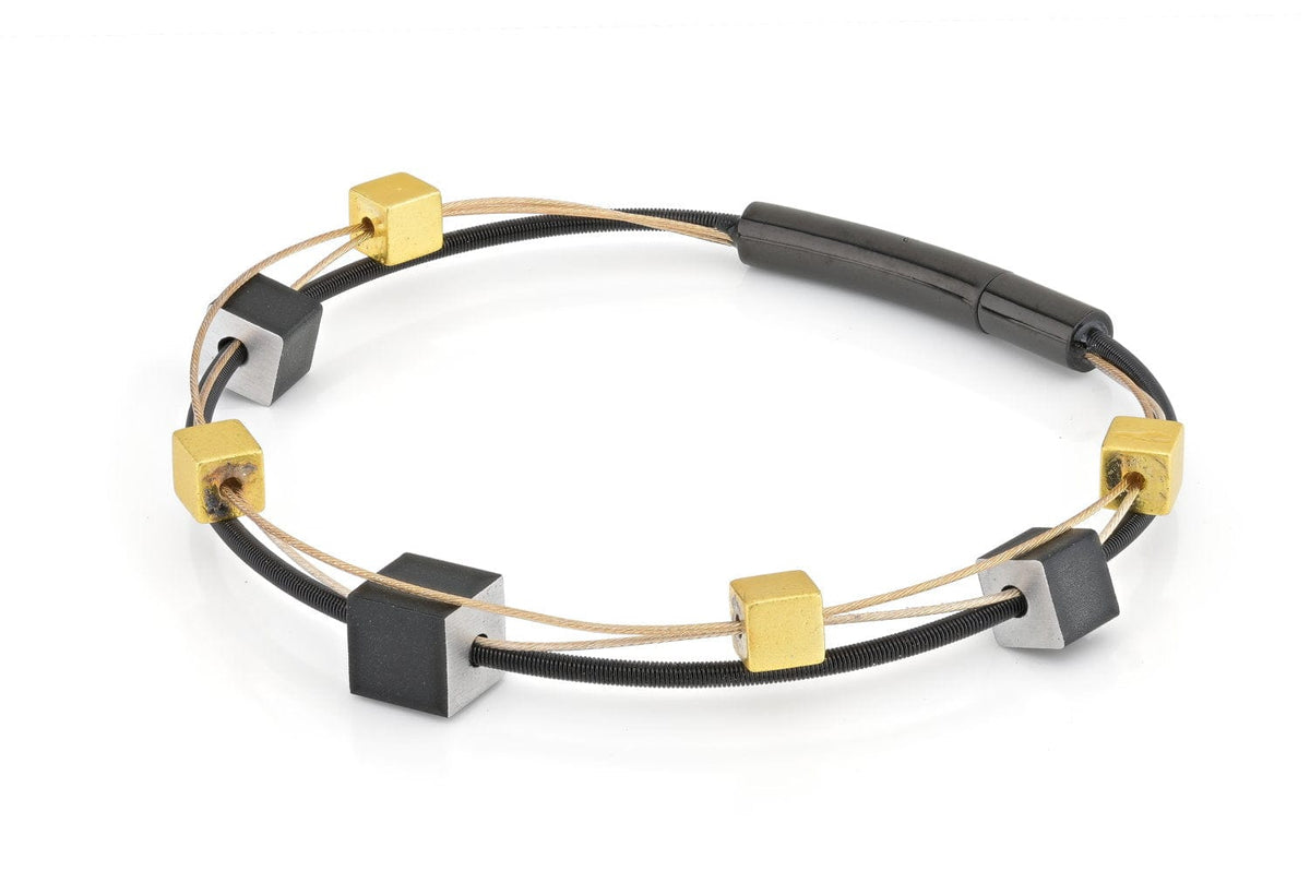 Armband mit goldfarbenen und schwarzen Würfeln, kombiniert mit einem schwarzen Band