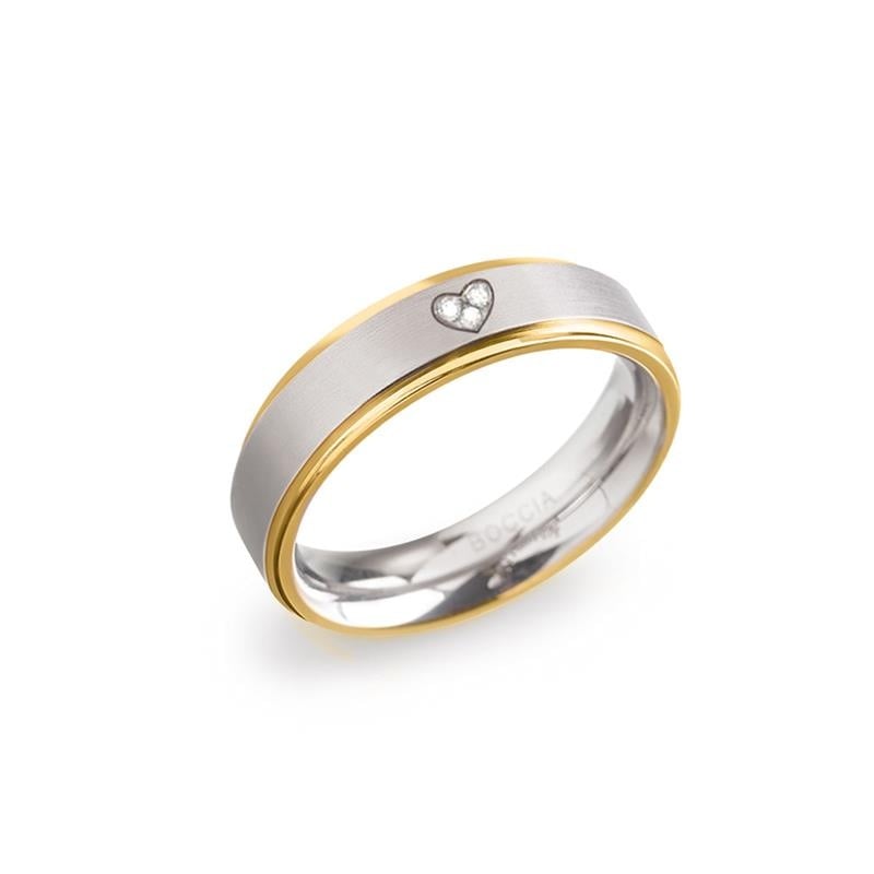 Bicolor Titanring mit glänzendem, silbernem Gehäuse und goldfarbener Lünette sowie einem kleinen Herz mit Steinchen