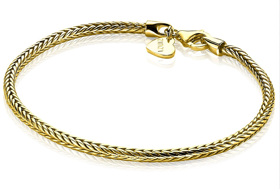 De vergulde gevlochten armband van Zinzi, Zia1287 G, heeft een karabijnsluiting en een klein hartvormig label bij de sluiting.