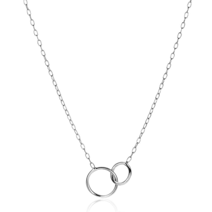 De Zinzi Ketting Zilver Zic2275 van Zinzi heeft twee in elkaar grijpende zilveren cirkels - een grote, een kleine - als hanger aan een fijne ketting, tegen een effen witte achtergrond.